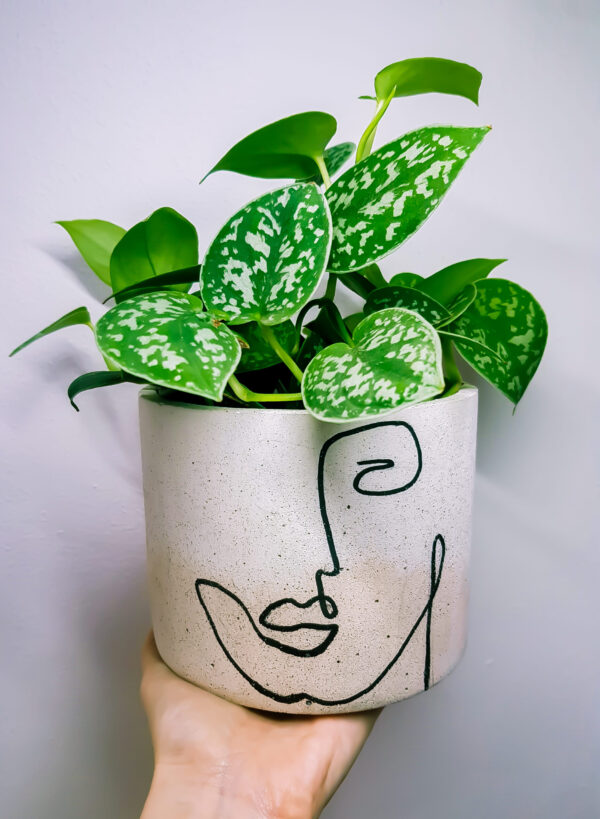Vaso in cemento bianco e rosa decorato con volto