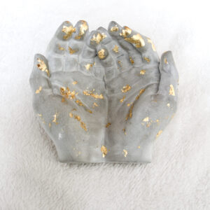 Mani in cemento e oro